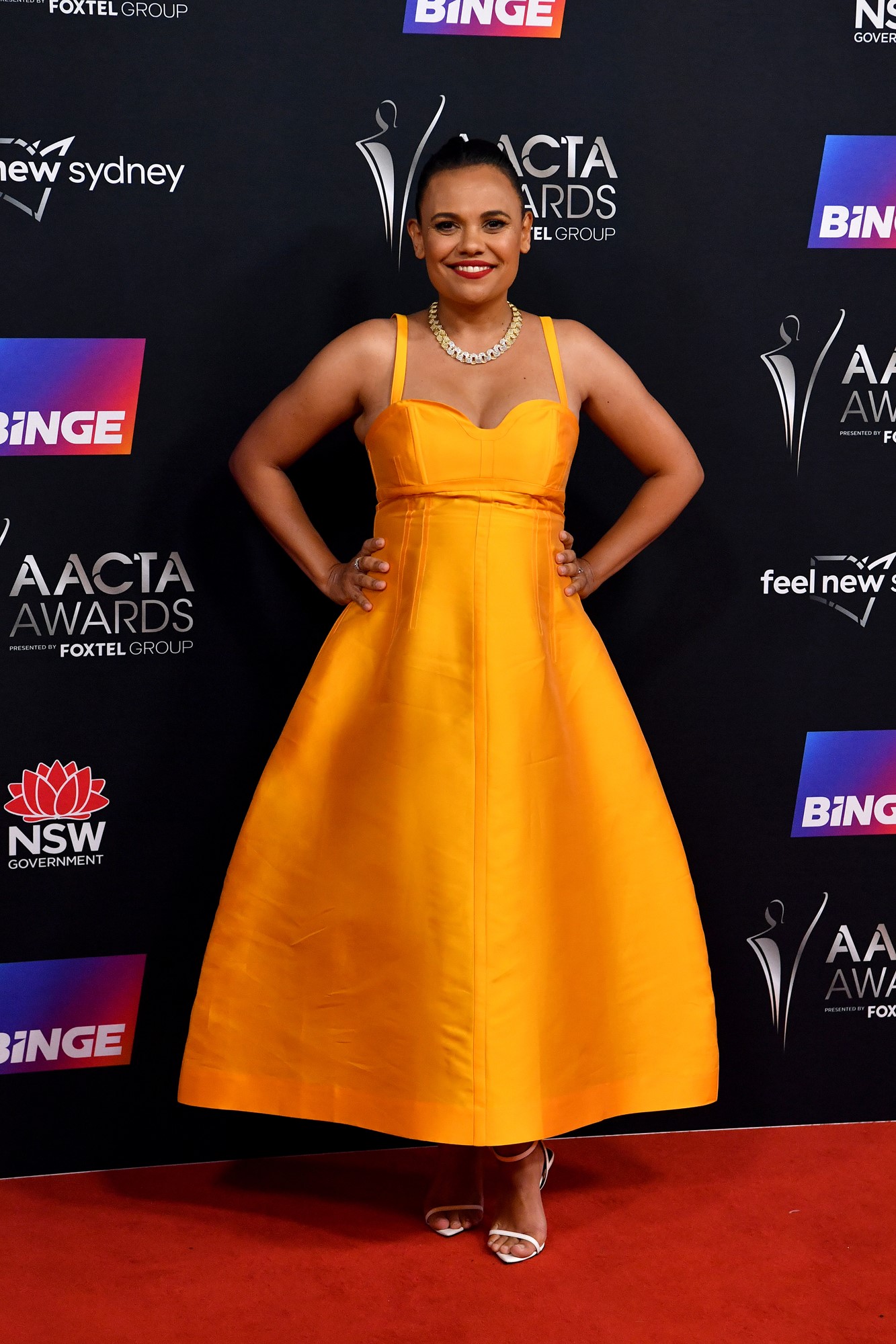 Miranda Tapsell in an orange gown.