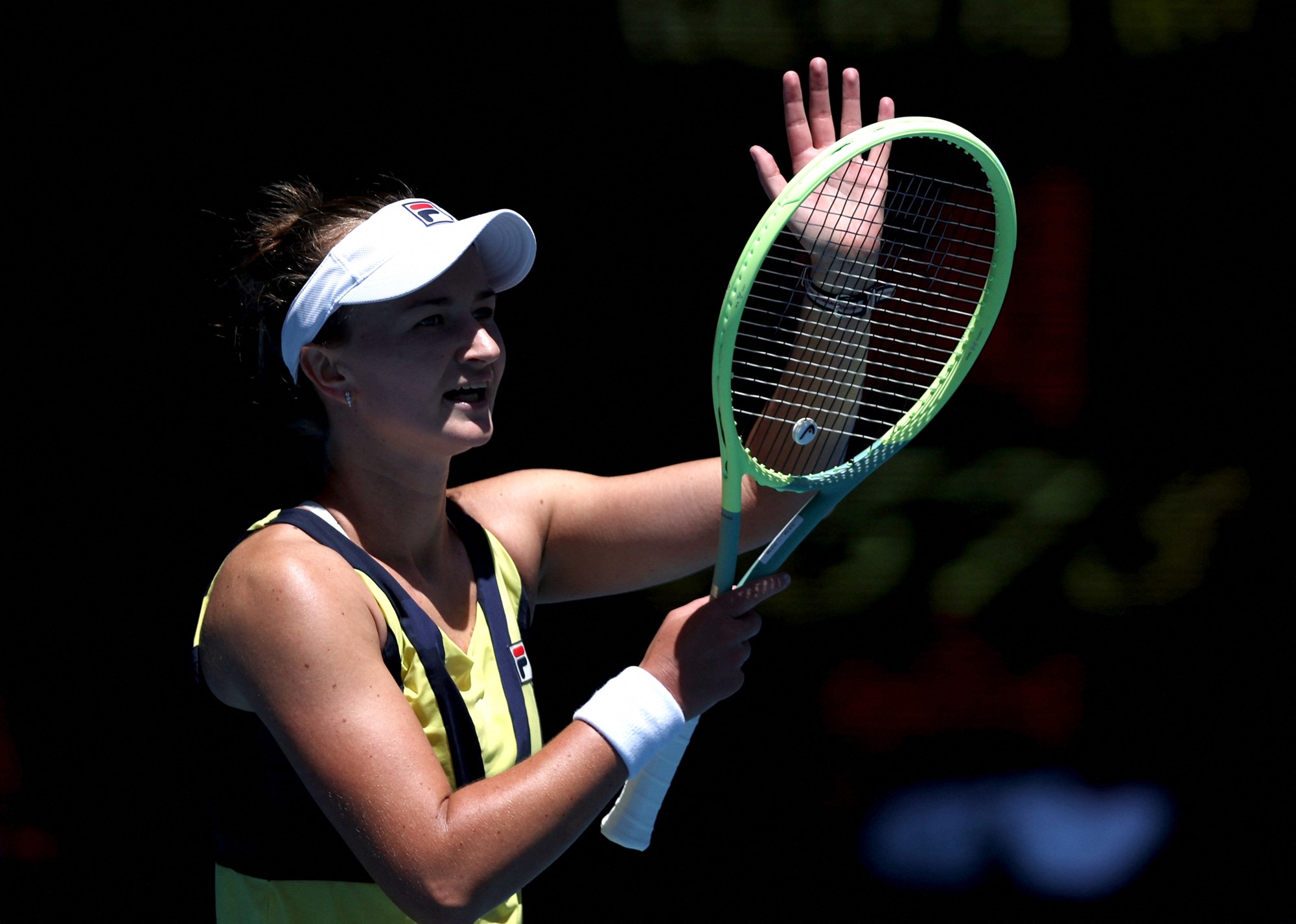 A tennis player applauds the crowd.