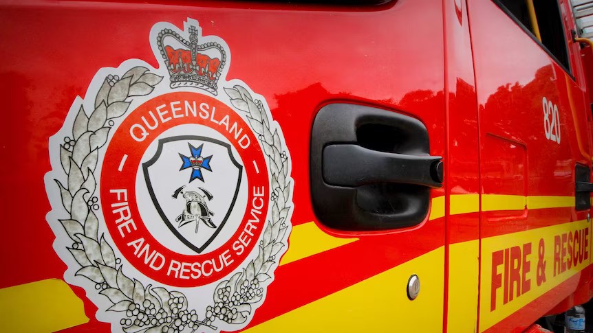 A logo of the Queensland Fire and Rescue Service on a red fire truck.