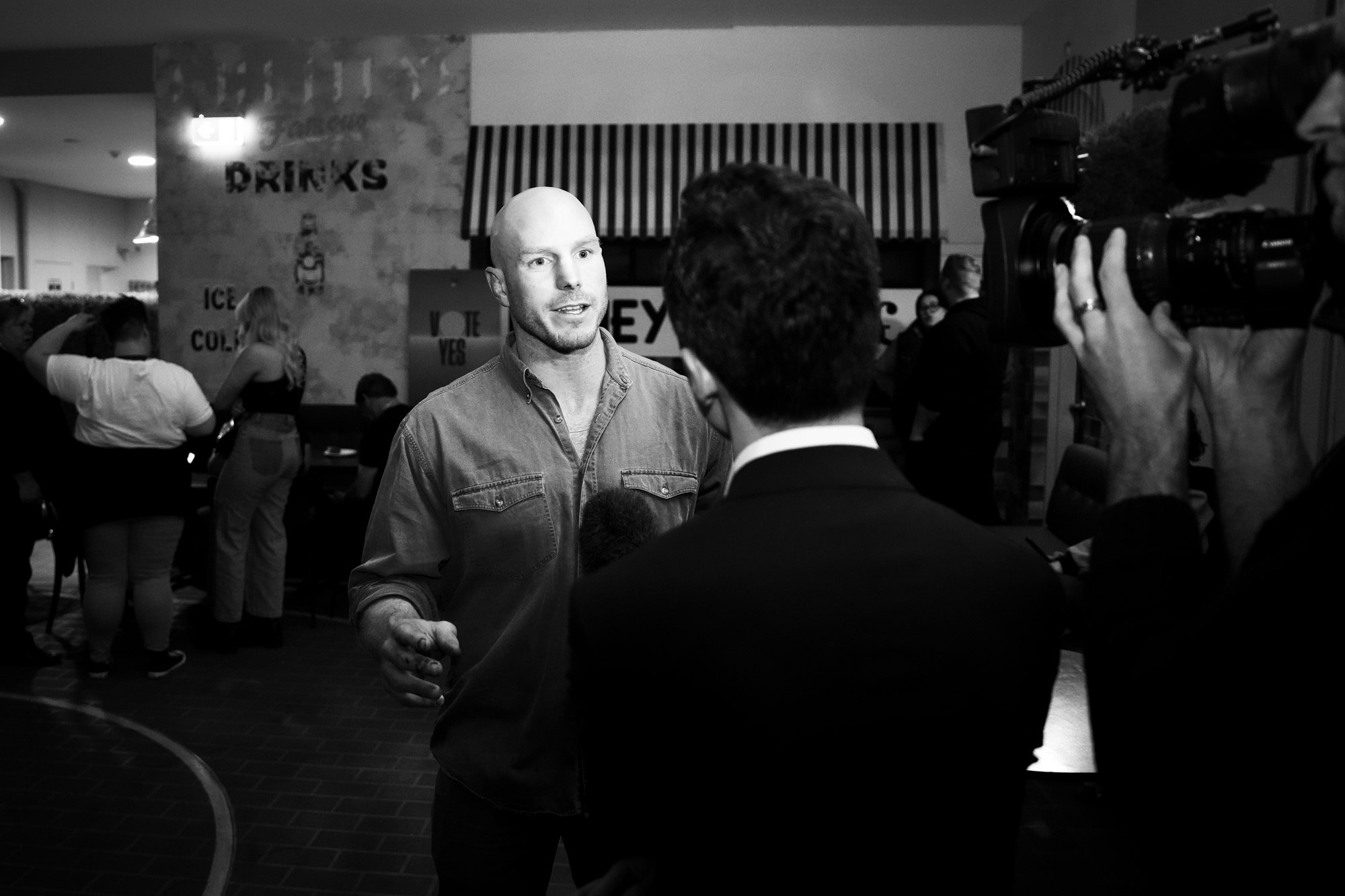 A black and white photo of David speaking to a reporter.