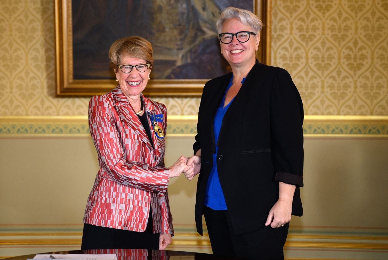 Two women shake hands