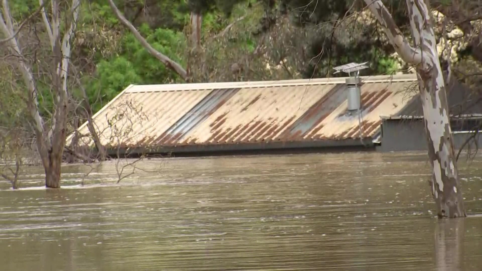Picture shows just the roof of a house seen in floodwaters.