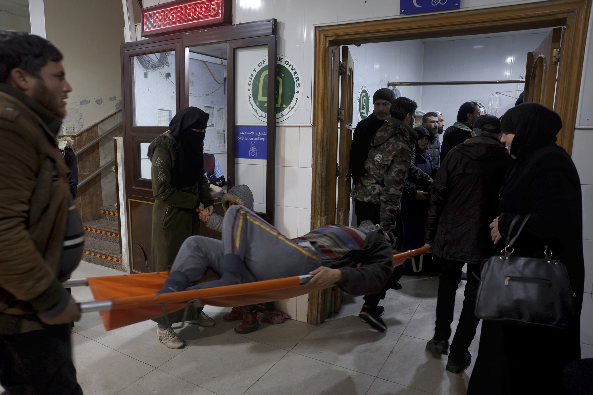People carry a man injured in an earthquake into the al-Rahma Hospital in the town of Darkush, Idlib province, northern Syria.
