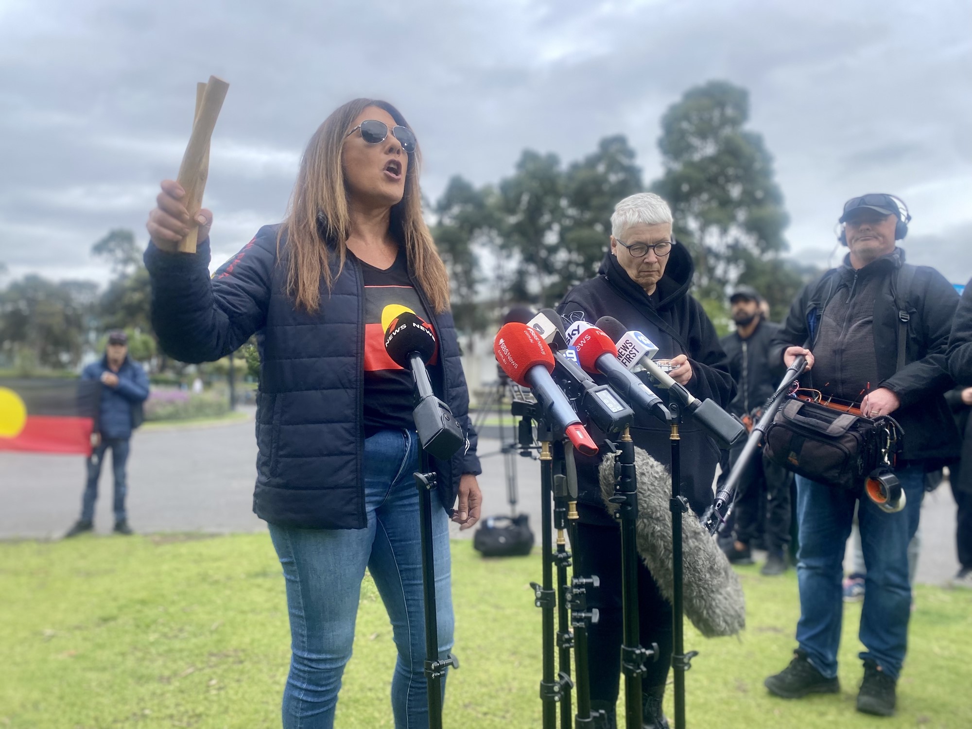 A woman speaking to a set of media microphones