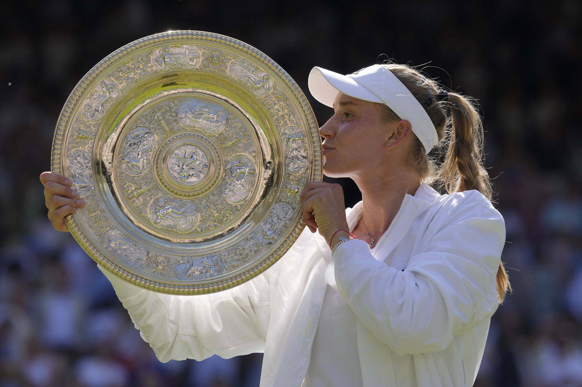 Elena Rybakina kisses the Wimbledon trophy.