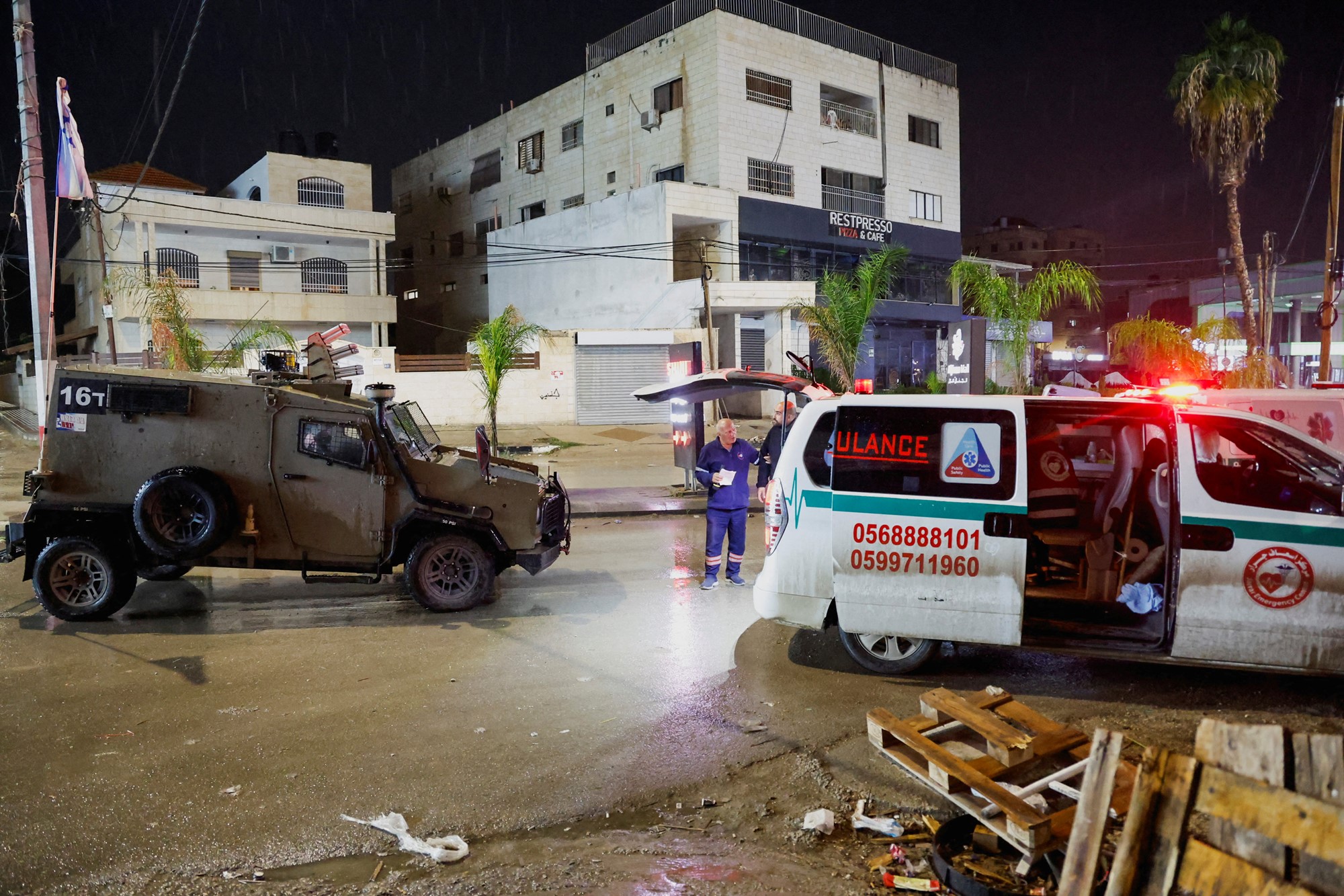 An armoured vehicle in front of an ambulance