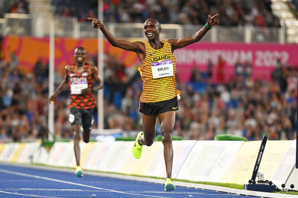 Uganda's Jacob Kiplimo runs over a finish line with a massive smile and his hands in the air