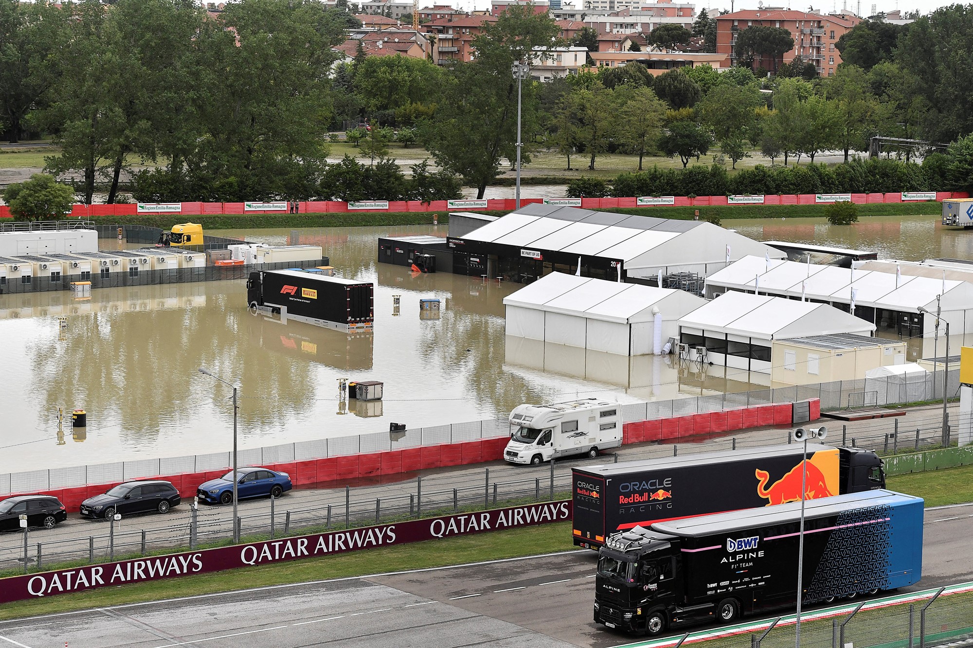 A flooded paddock next to a race car track.