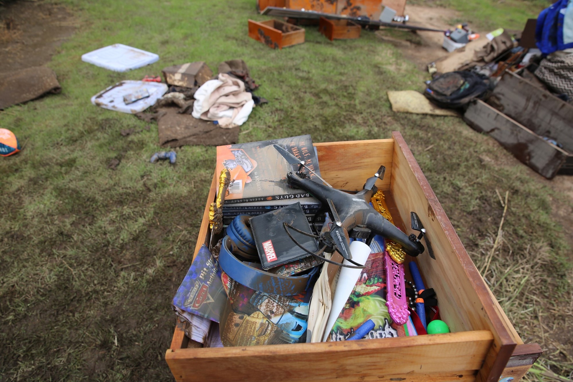 A draw full of water damaged items sits on the lawn