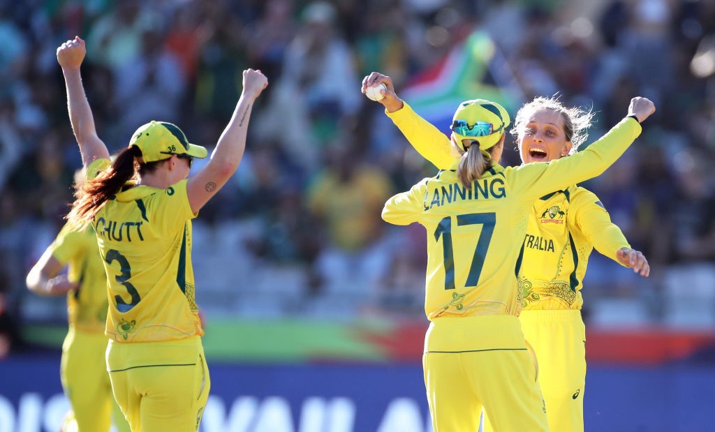 Australia cricketers Meg Lanning, Ashleigh Gardner and Megan Schutt raise their arms and hug as they celebrate victory in the women's Twenty20 World Cup final.