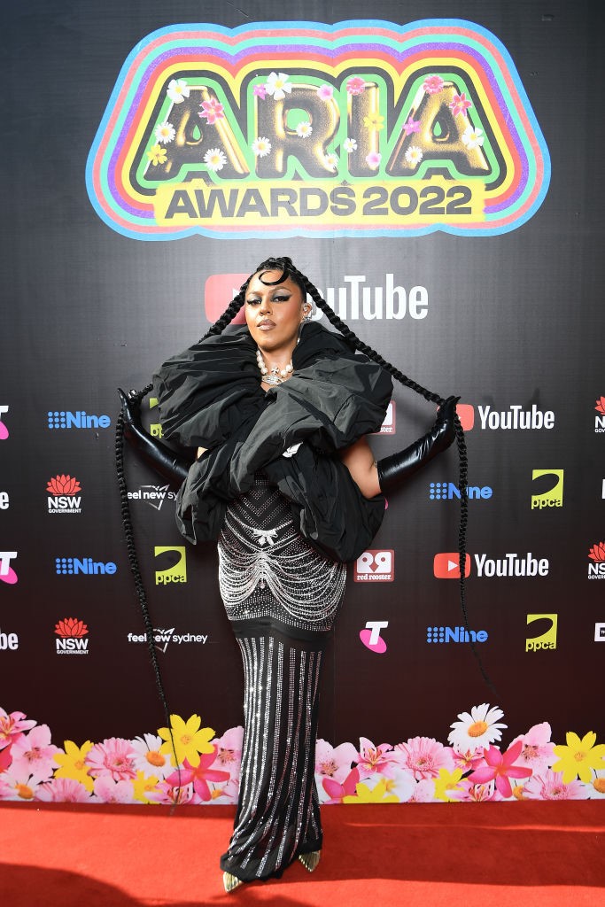 BARKAA poses on red carpet wearing black gown with embellishments