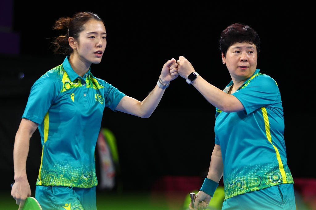 Jian Fang Lay and Minhyung Lee fist-bump each other during a table tennis match