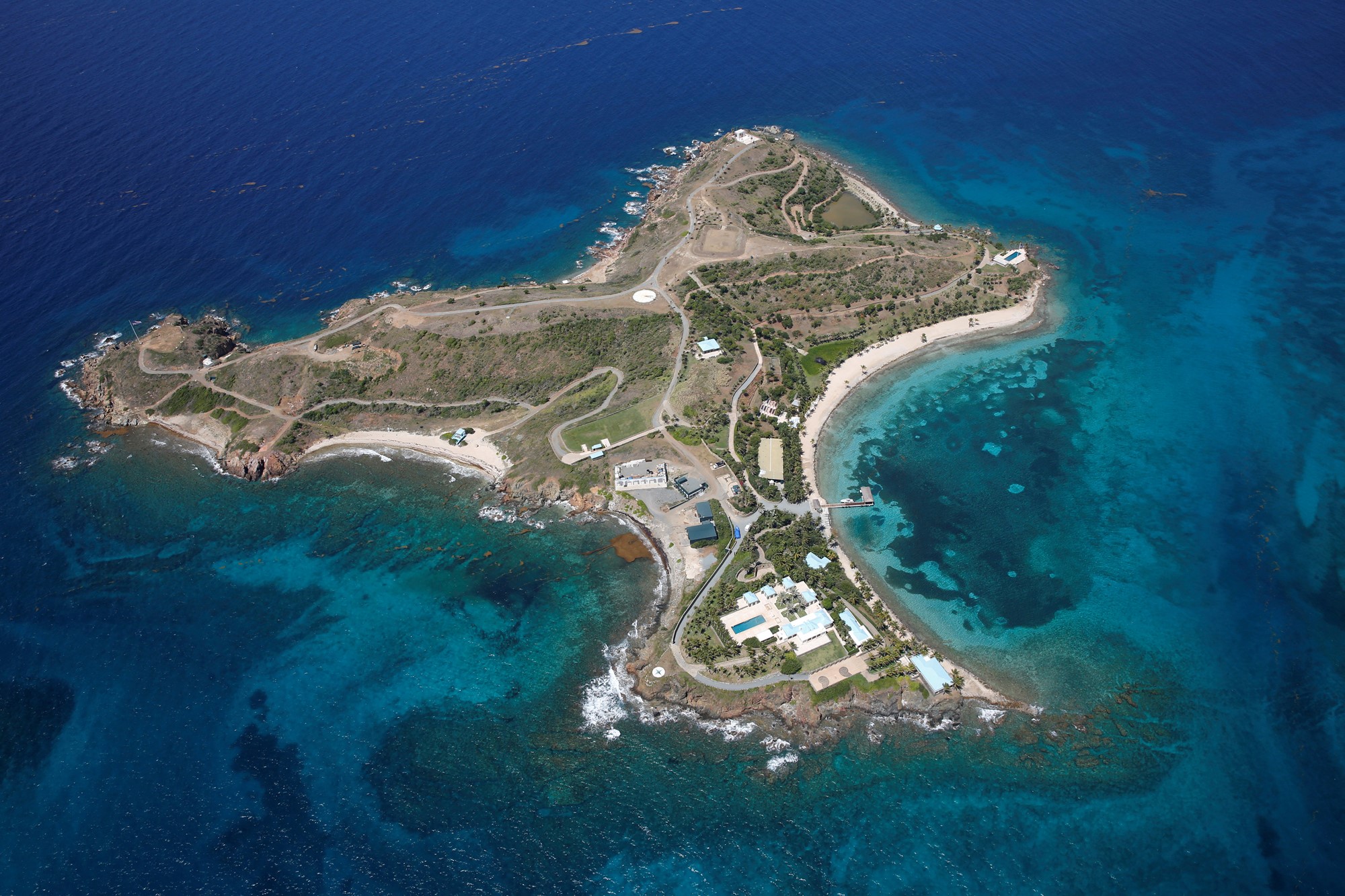 An aerial photo of a small private island with some buildings and roads
