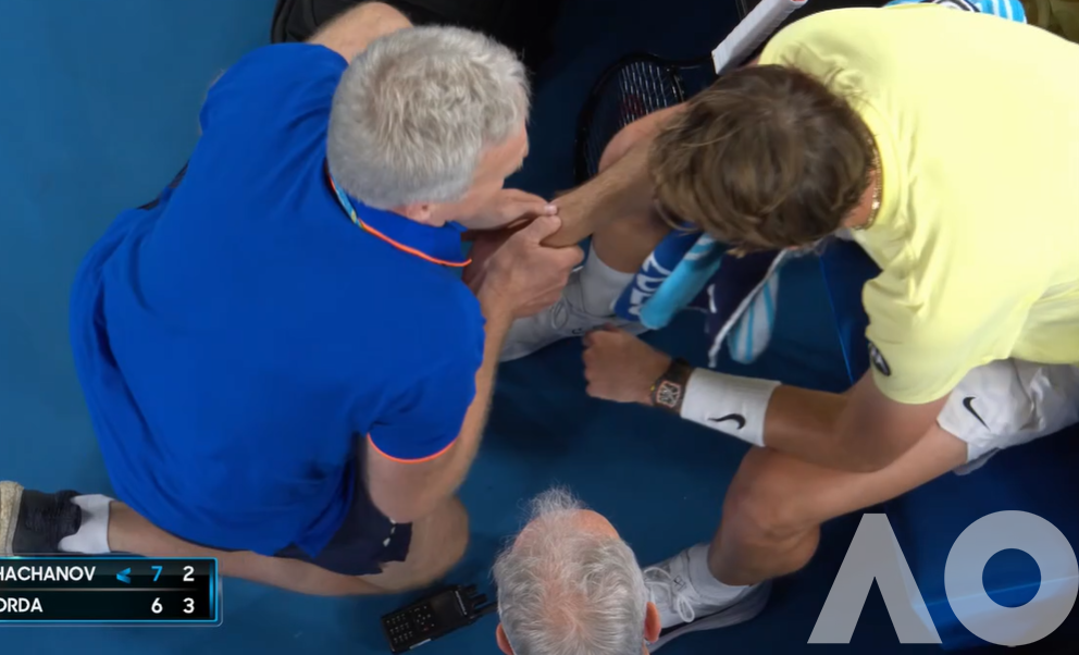 A physio checka sa tennis player's wrist.