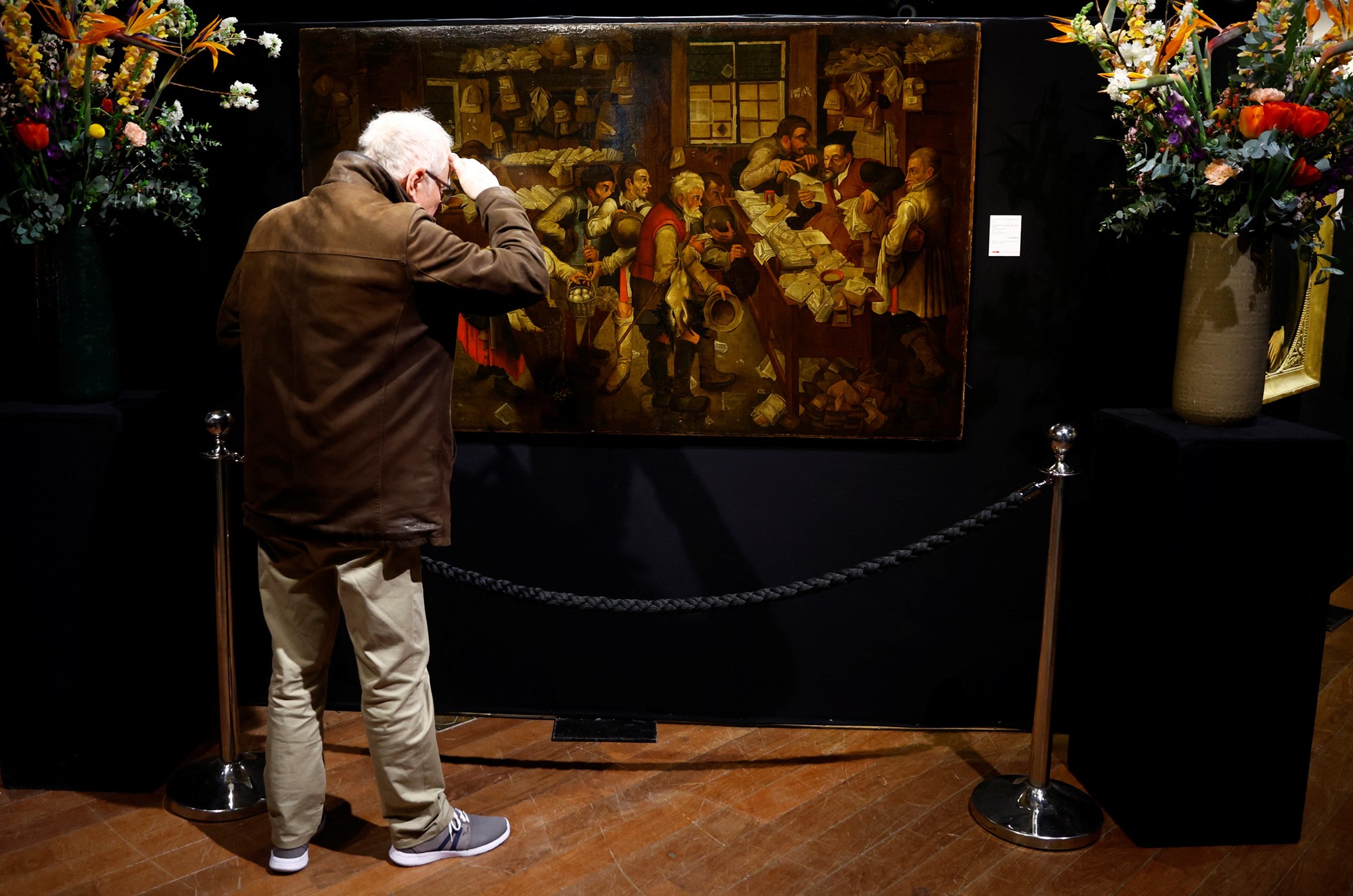 A man looks at a painting. 