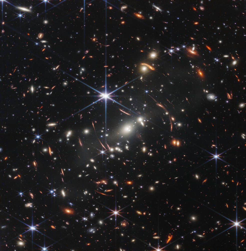 A galaxy with a black background covered in stars and curved bits of light.