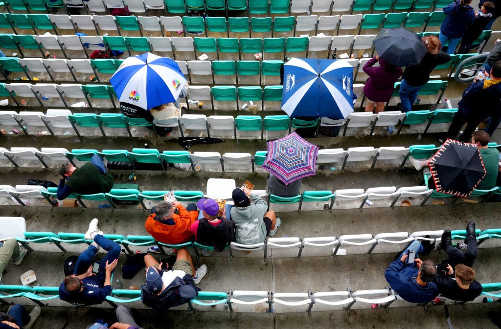 A bird's eye view of people at The Oval with umbrellas during an Ashes Test.
