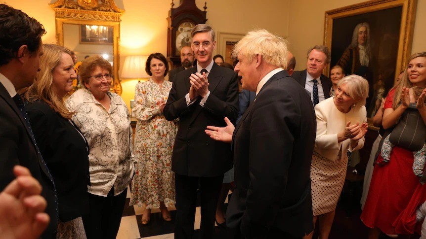 Boris Johnsons's staff stand around him, some applaud.