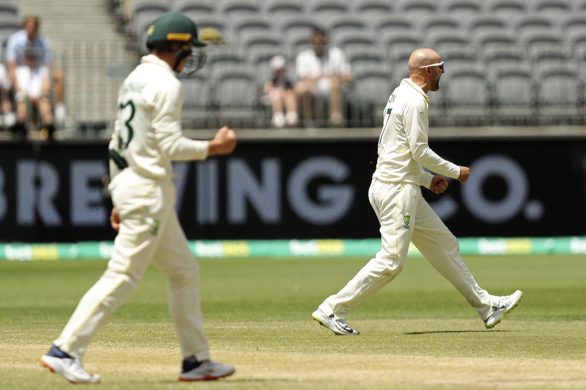 Australia bowler Nathan Lyon fist pumps after a wicket in the Test against West Indies. Marnus Labuschagne is in the foreground.