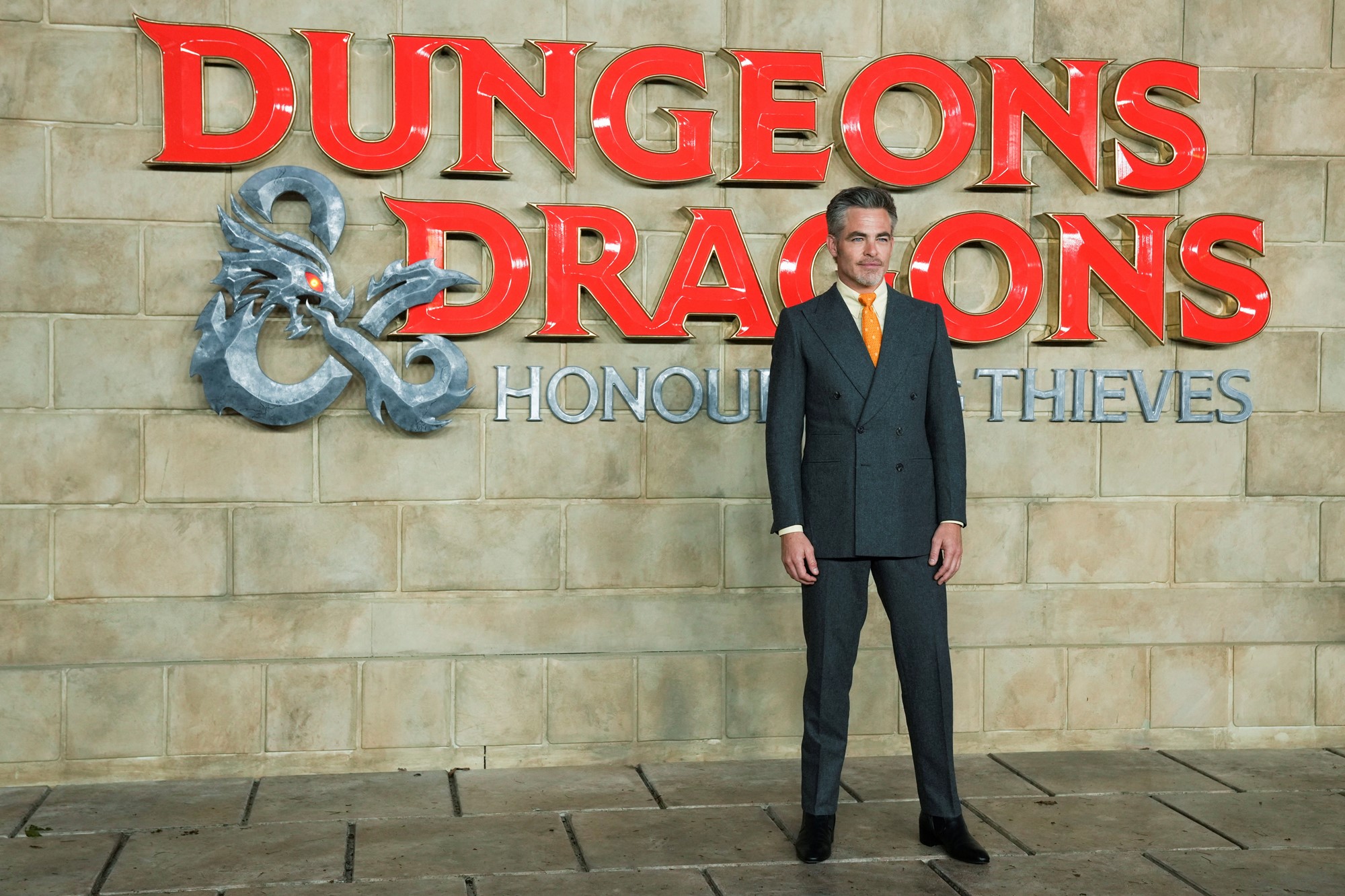 Chris Pine in front of a Dungeons & Dragons promotional sign. 
