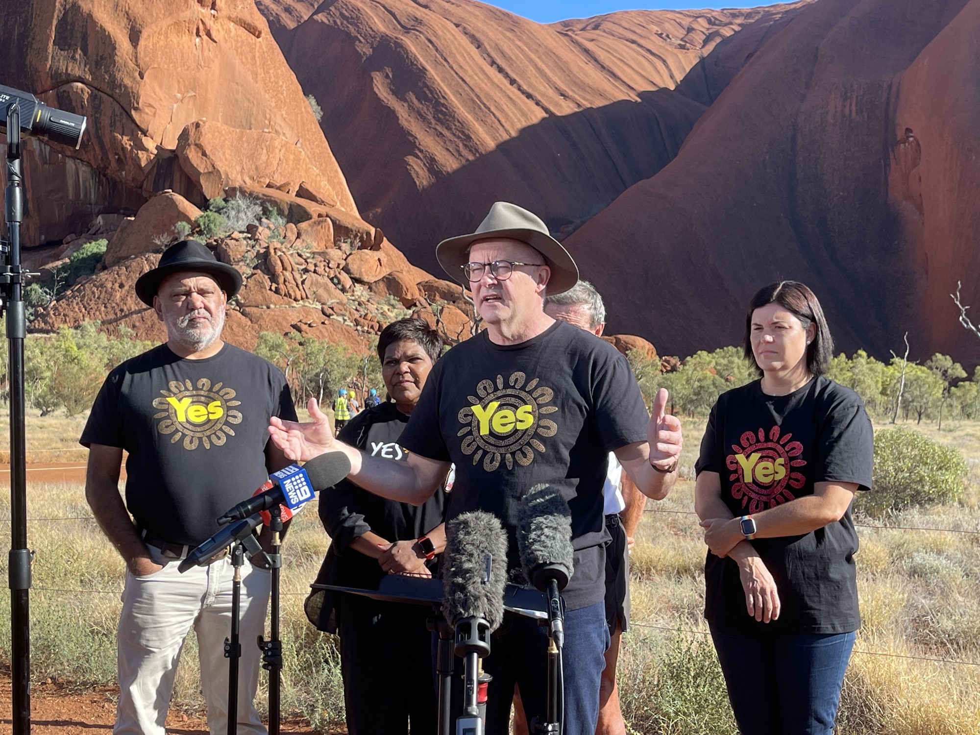 Albanese speaks at a press conference with the red rock seen behind the group.