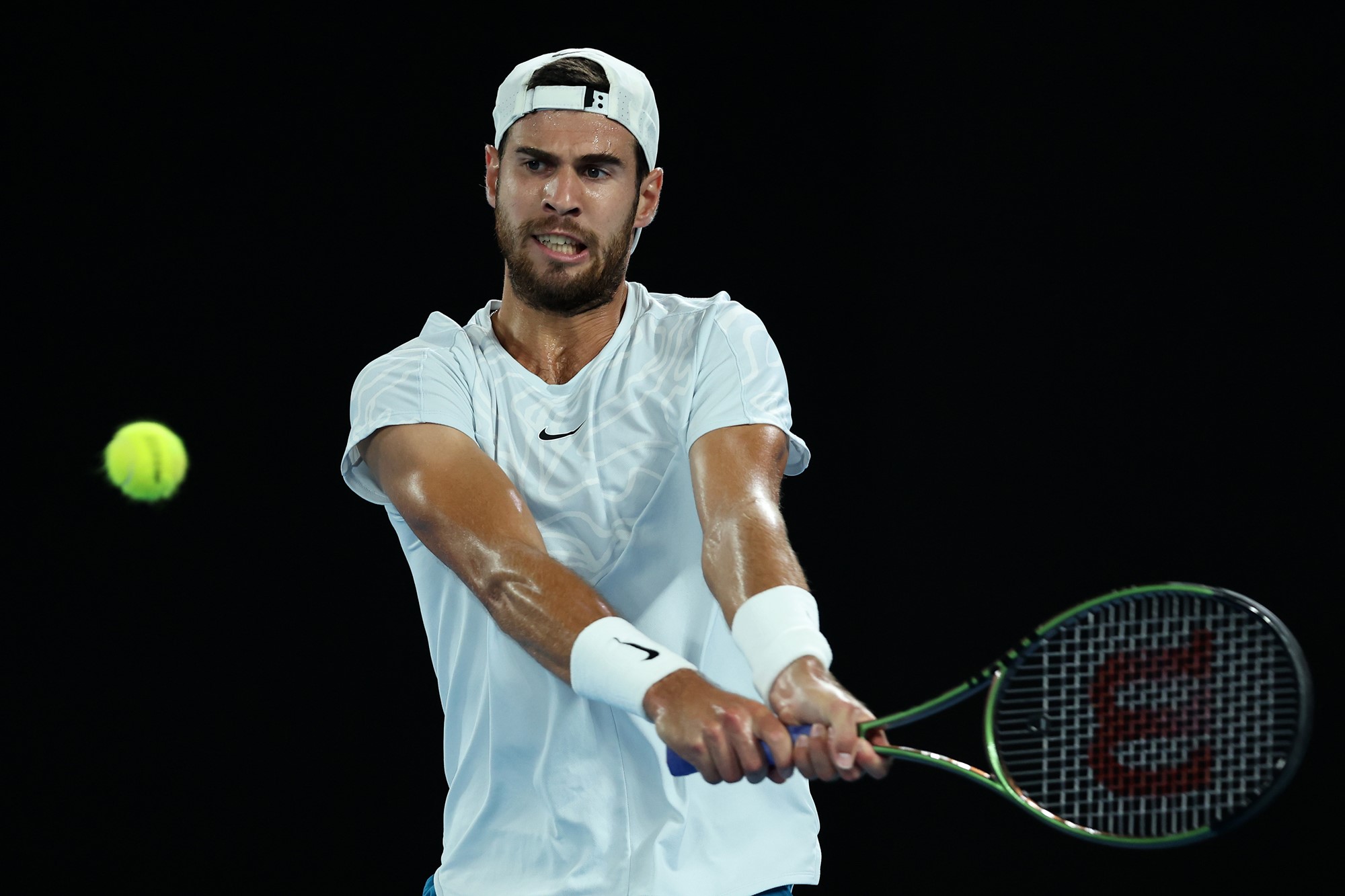 Karen Khachanov hits a backhand.