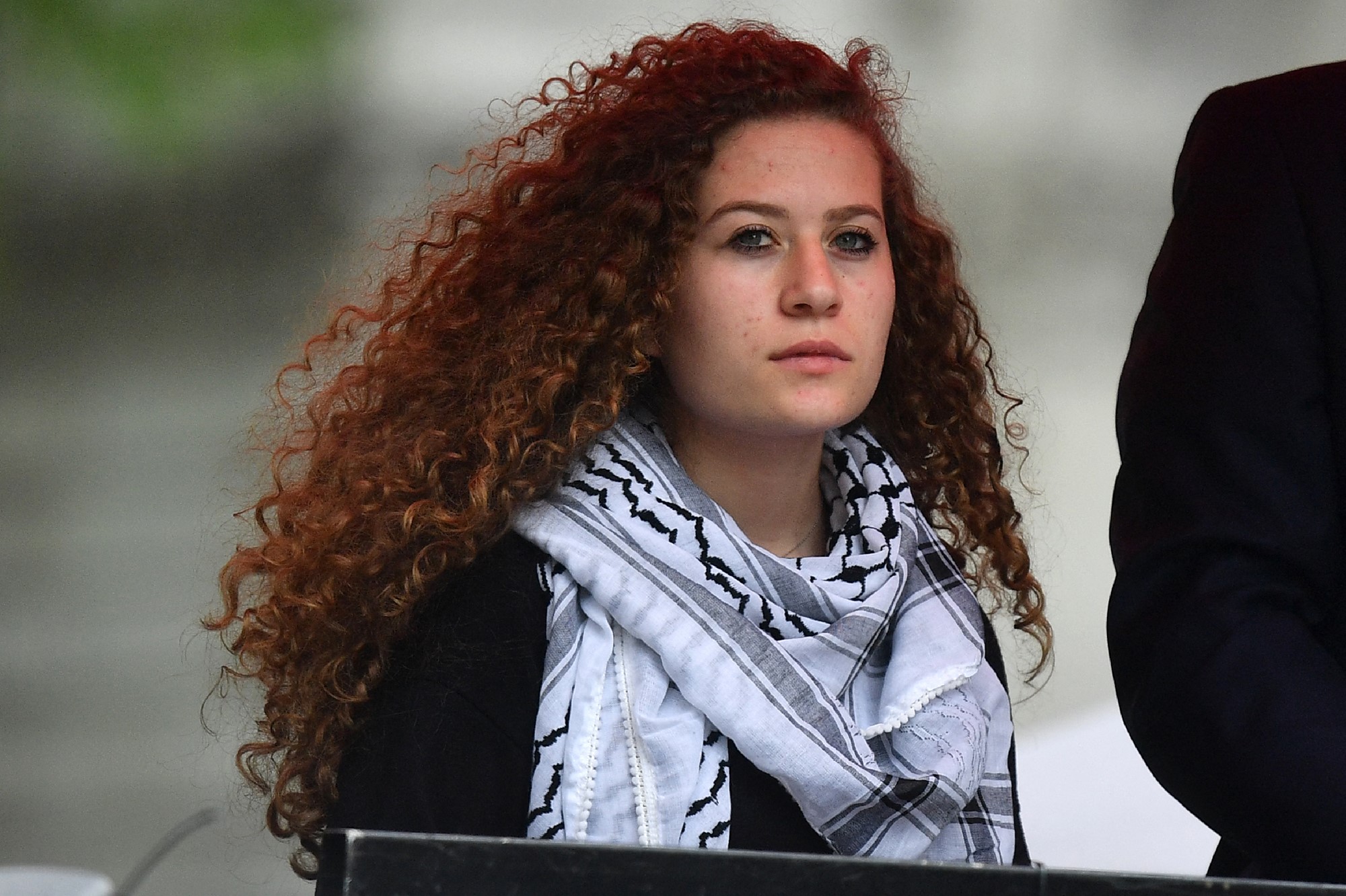 Woman with red curly hair wears scarf 