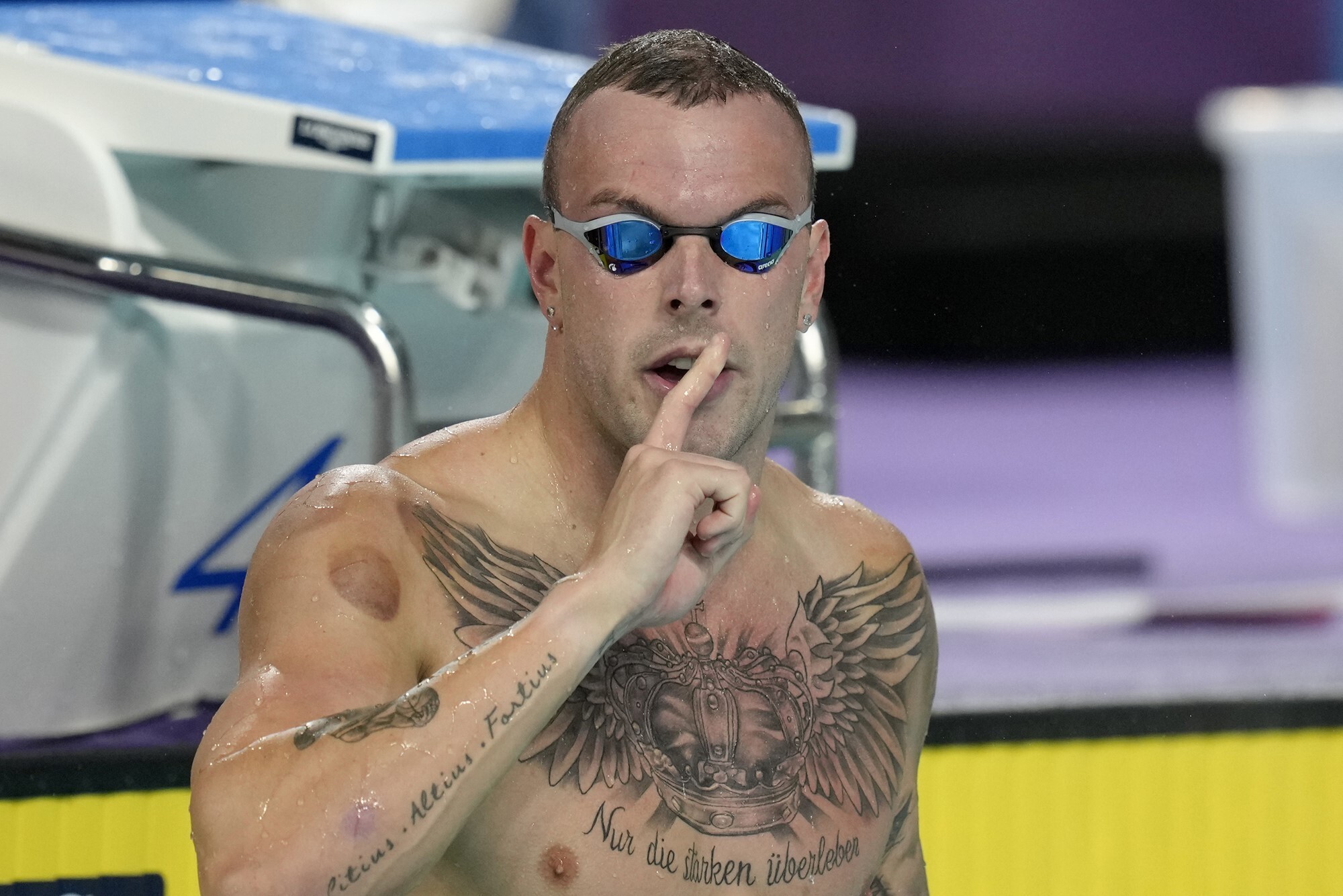 Swimmer Kyle Chalmers in a swimming pool, with a finger over his mouth 
