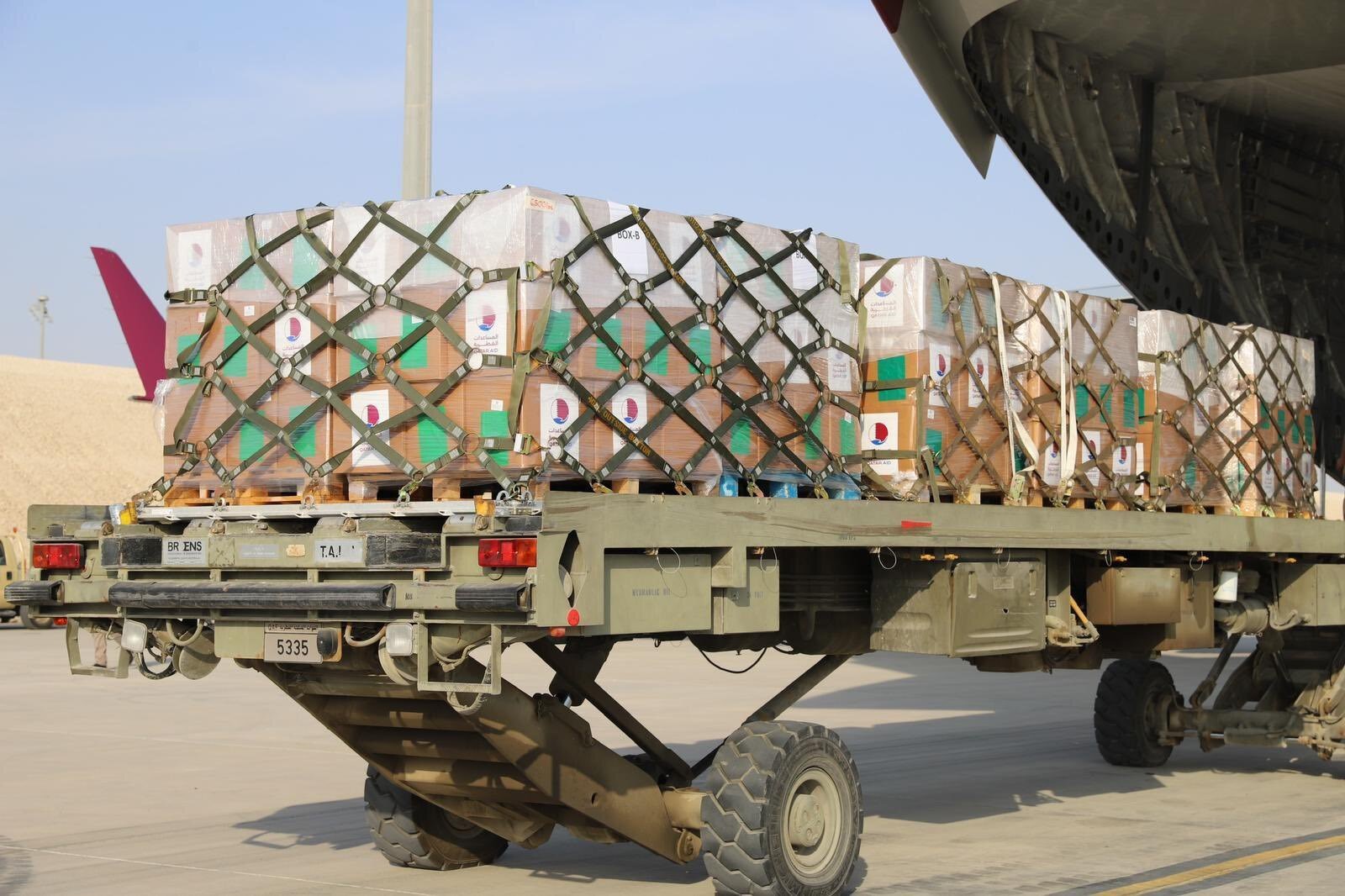 Photo of a truck loaded with boxes of aid labelled 'Qatar aid'. 
