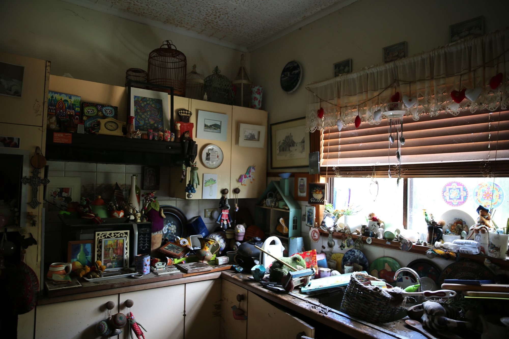 Items in a kitchen pile up on the benches and in the sink