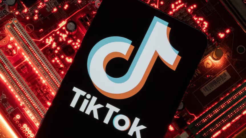 A close-up of the TikTok logo in front of a glowing computer-chip-style backdrop.