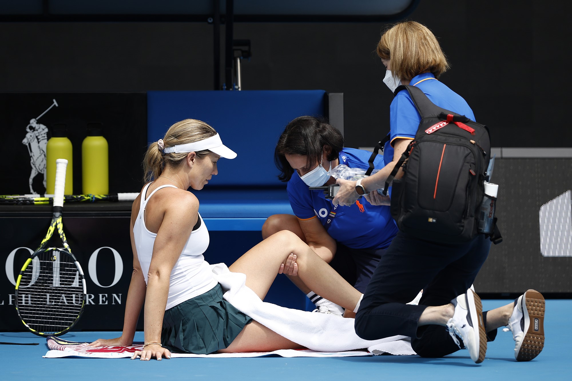 A tenis player receives treatment from a physiotherapist