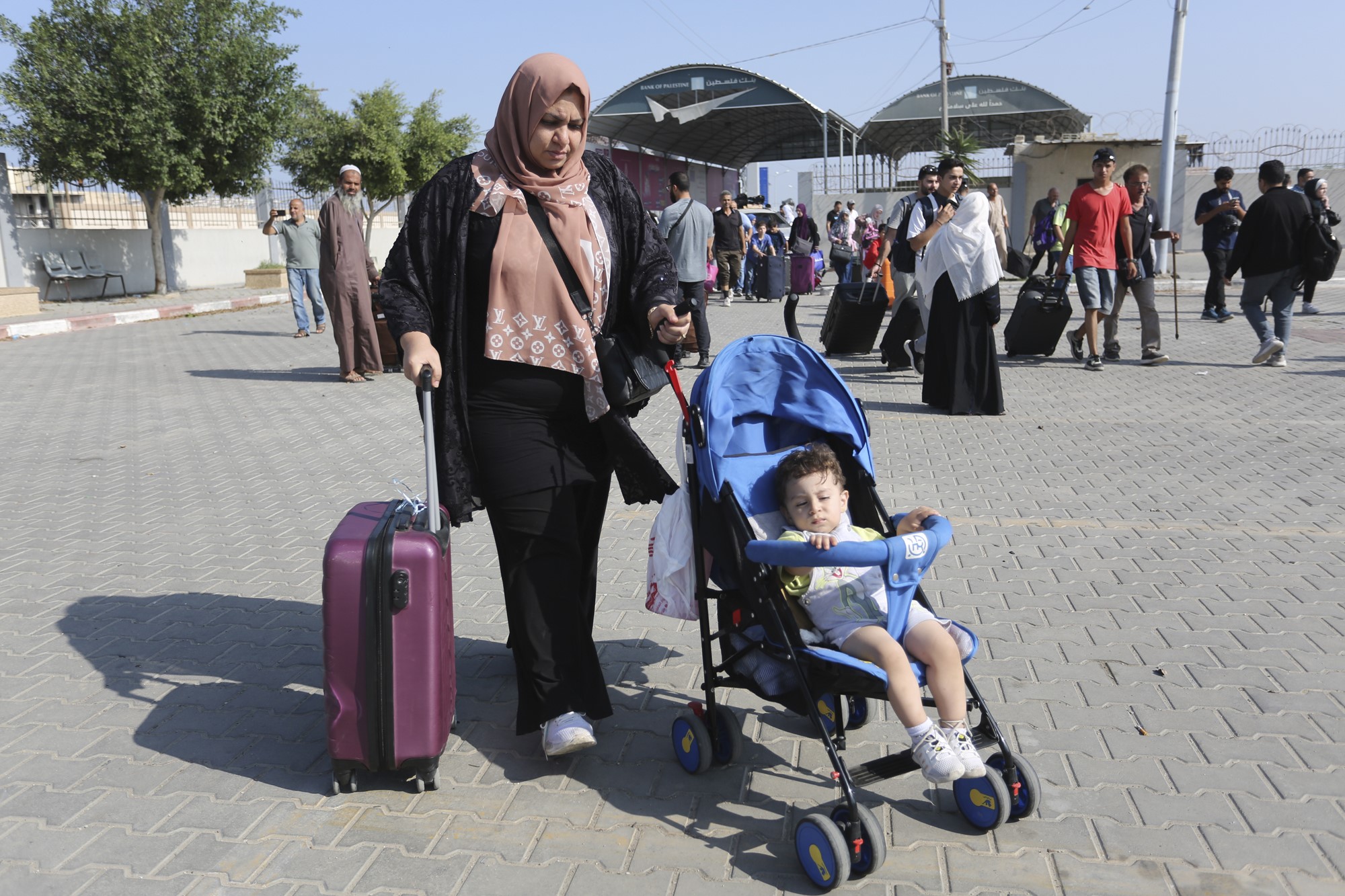mother in hijab wheels boy in stroller 