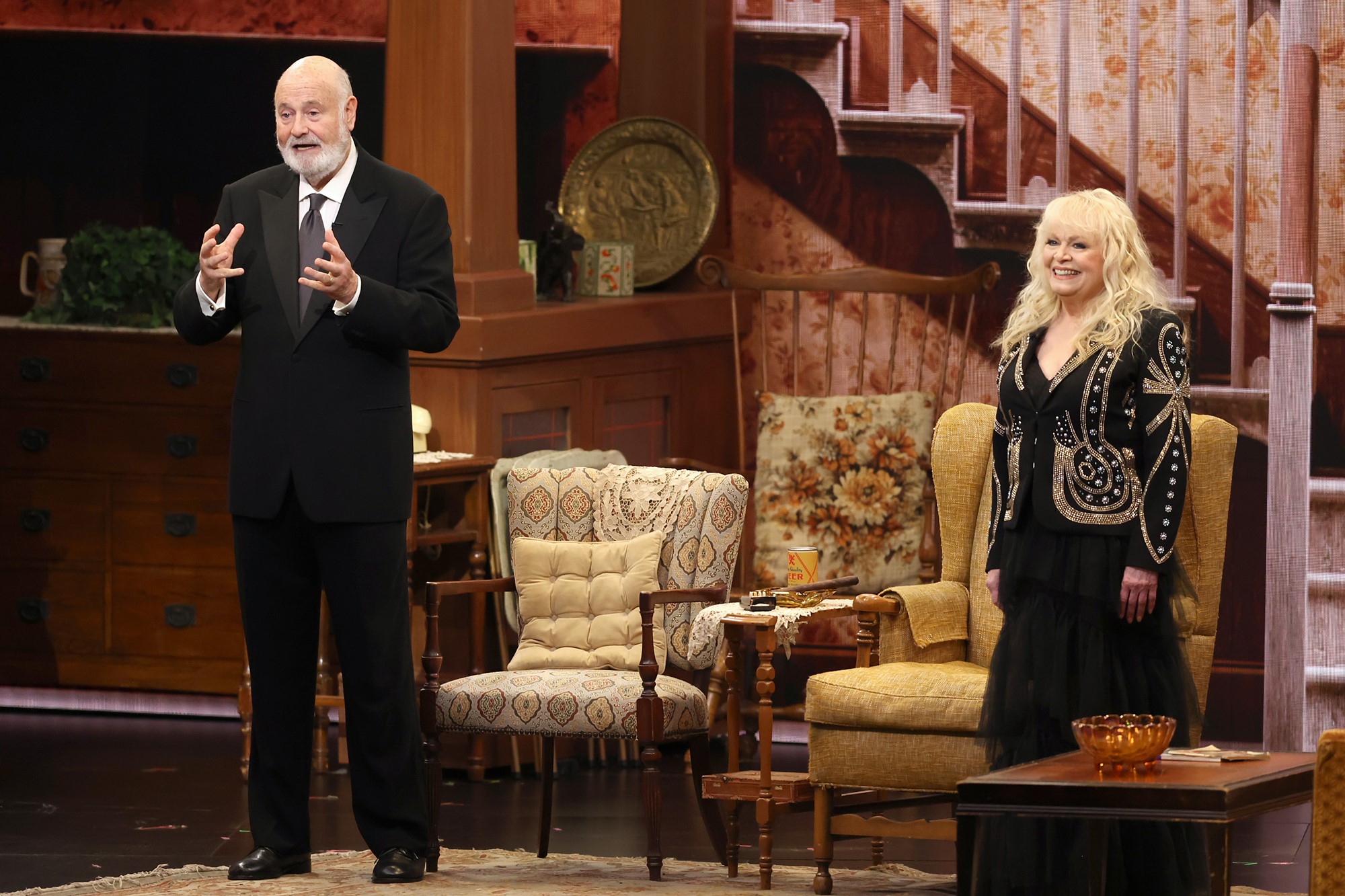 Rob Reiner and Sally Struthers in a living room set. 