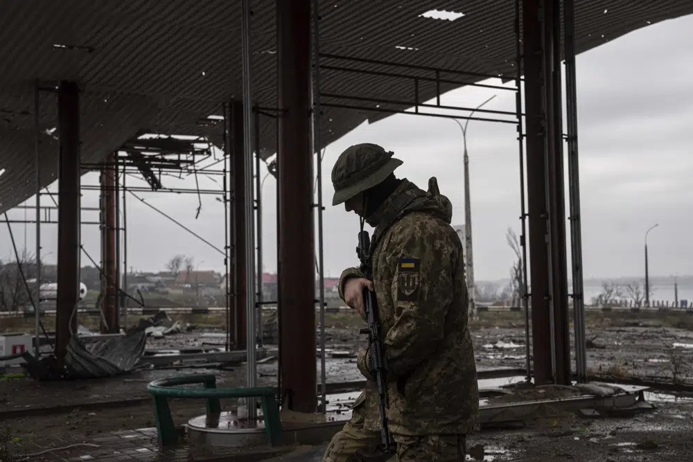 A Ukrainian soldier patrols near a bridge.
