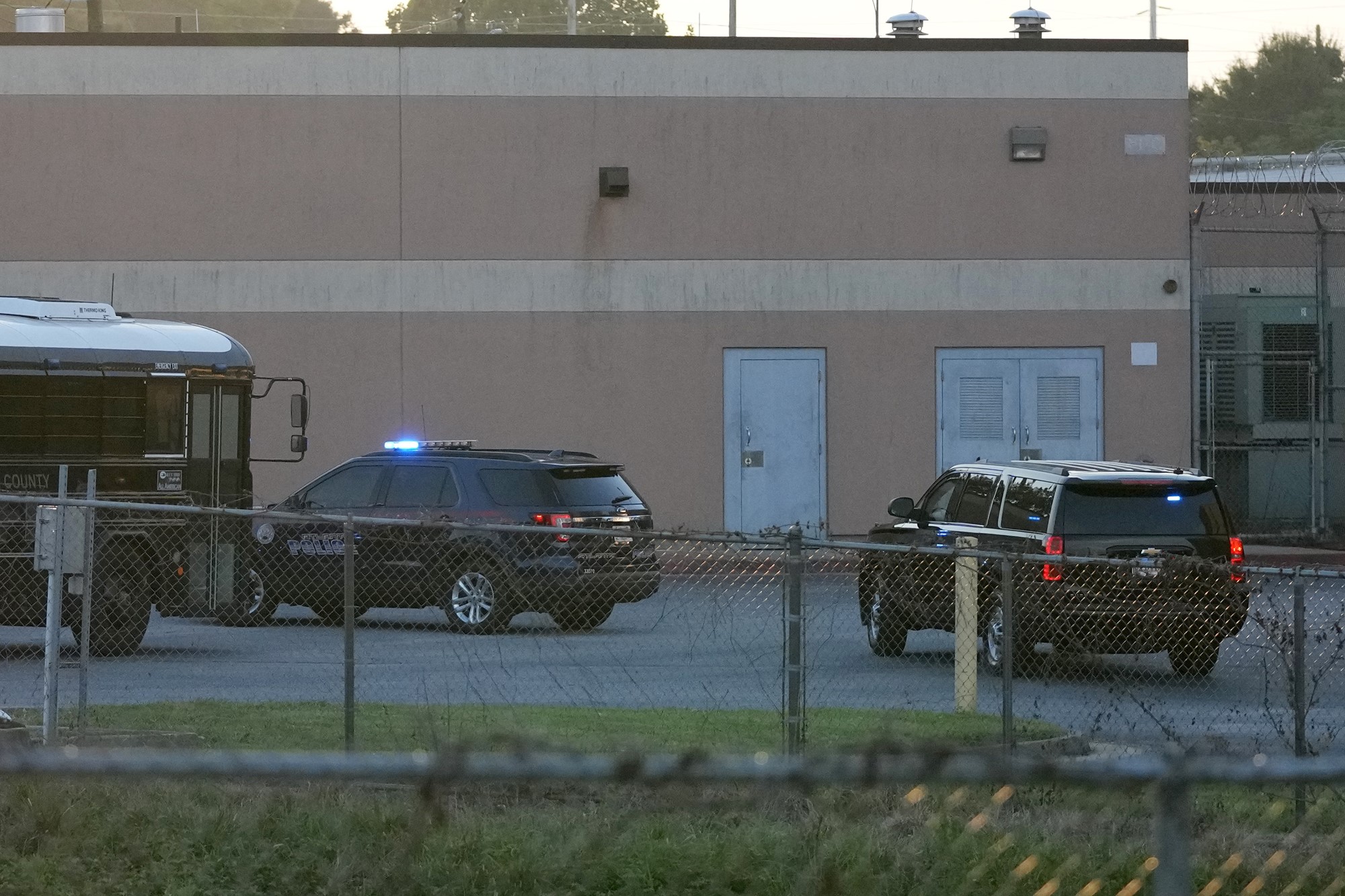 The vehicle carrying former President Donald Trump, right, arrives at the Fulton County Jail