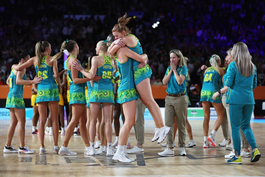 Australian netball players hug and clebrate after winning Commonwealth Games gold.