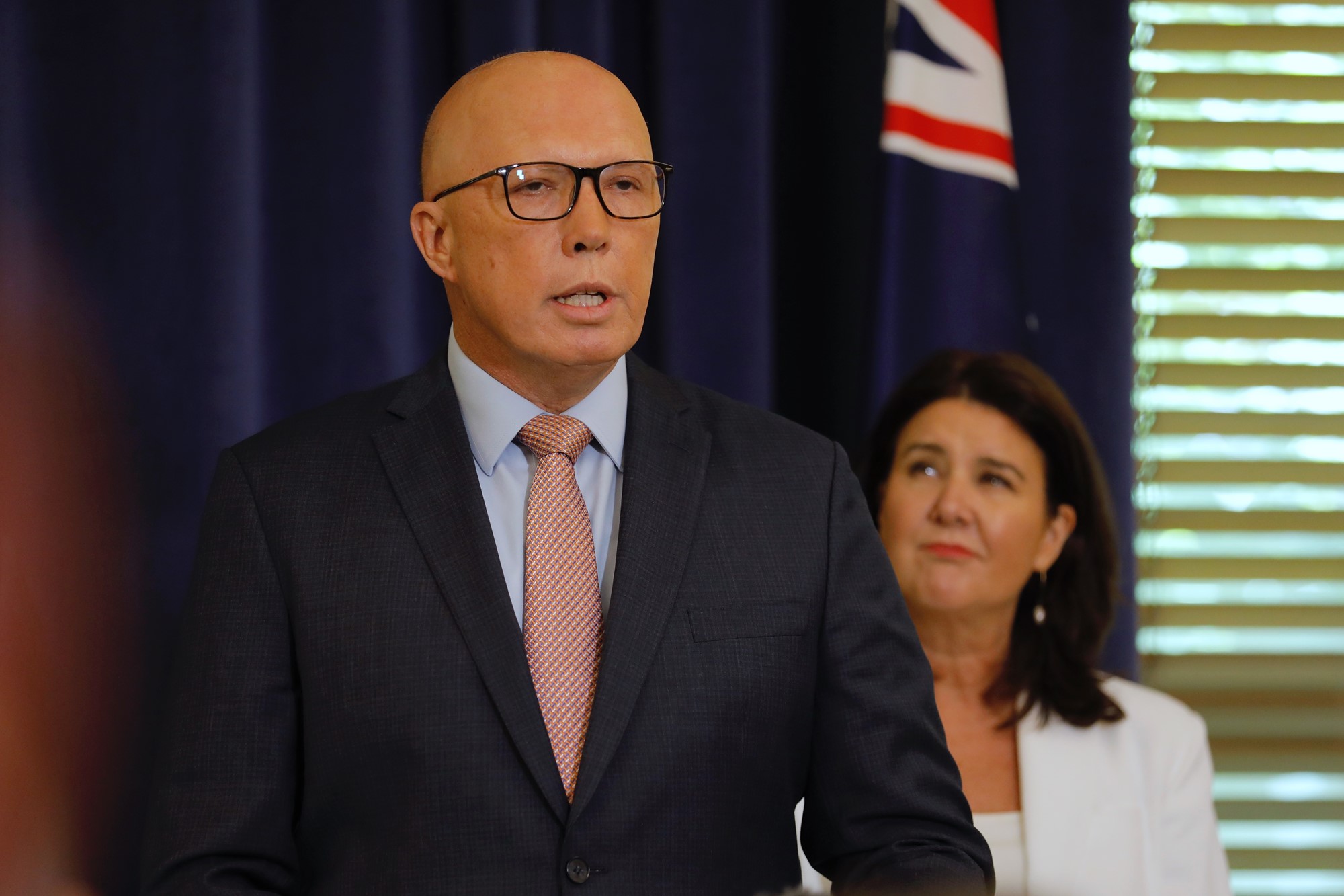 Peter Dutton in front of an Australian flag.