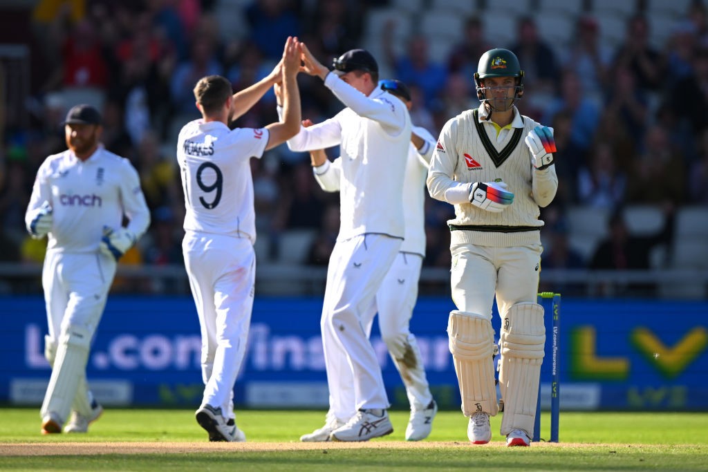 England players high-five as Australia batter Alex Carey walks off.