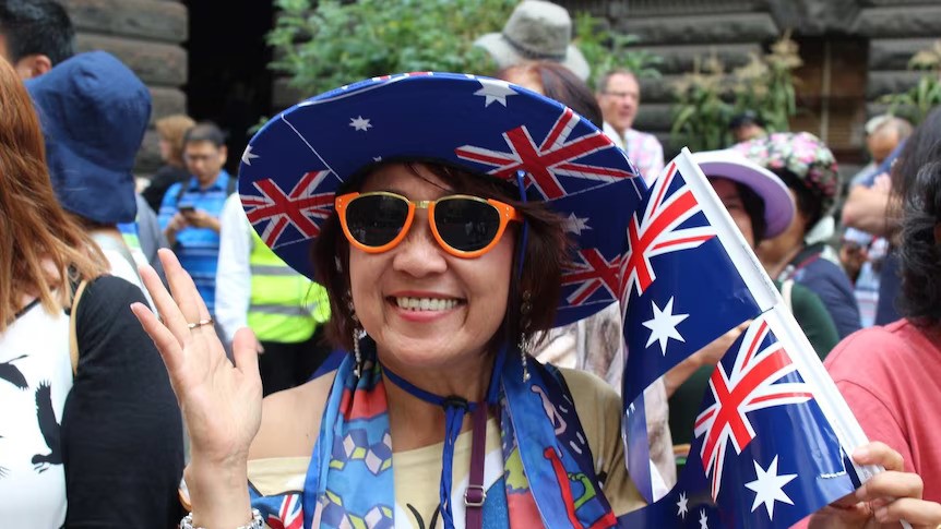 A woman weaing and holding Australian flag
