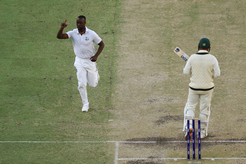West Indies bowler Keamar Roach runs past Australia batter Usman Khawaja after getting him out during the first Test at Perth Stadium.
