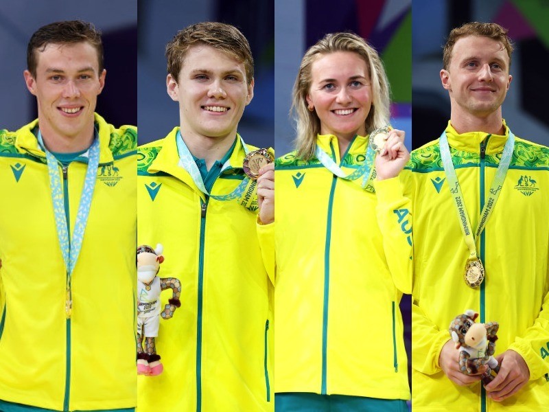 Four people stand in a line with medals around their necks