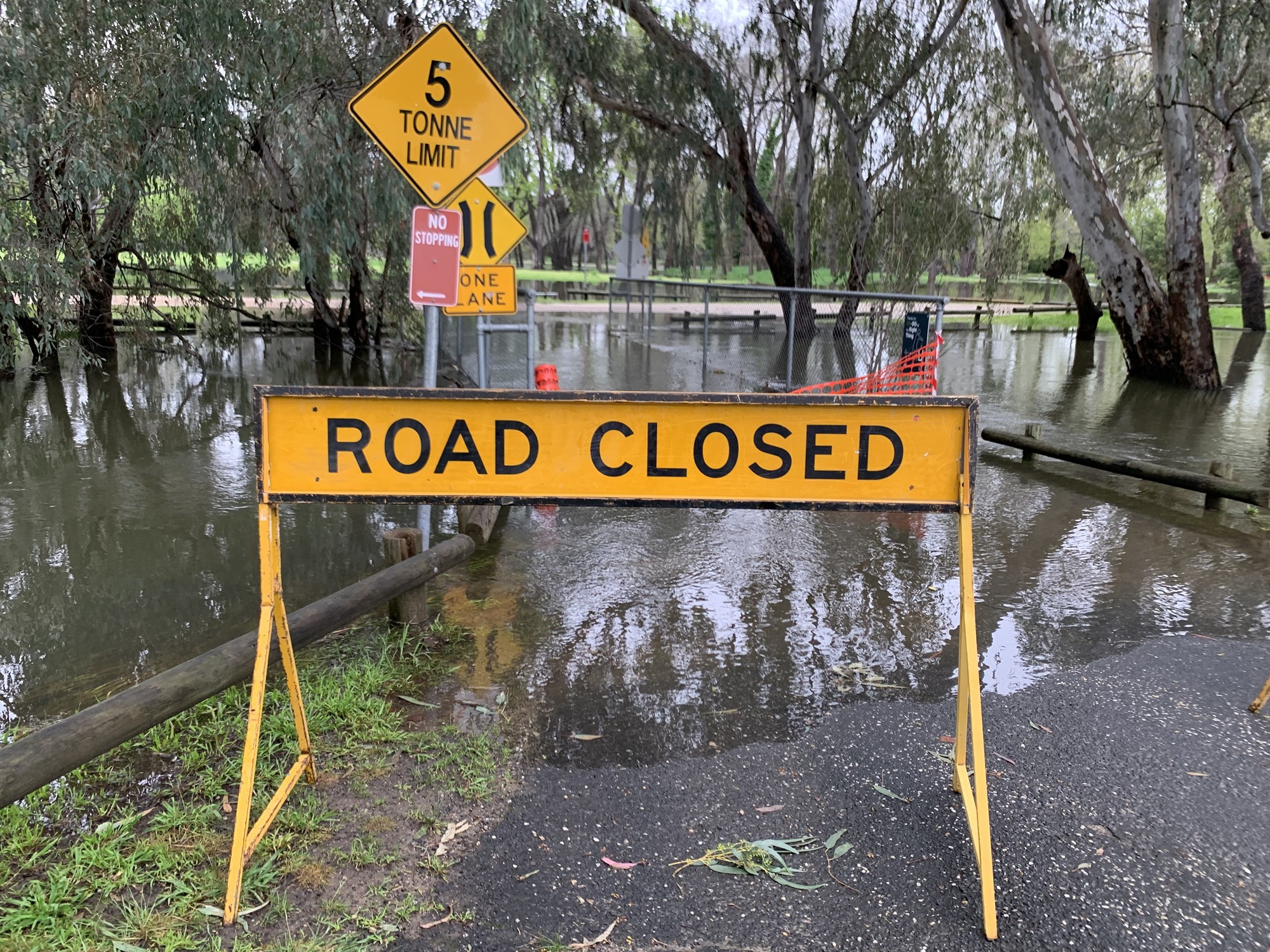 A road closed sign in front of floodwater