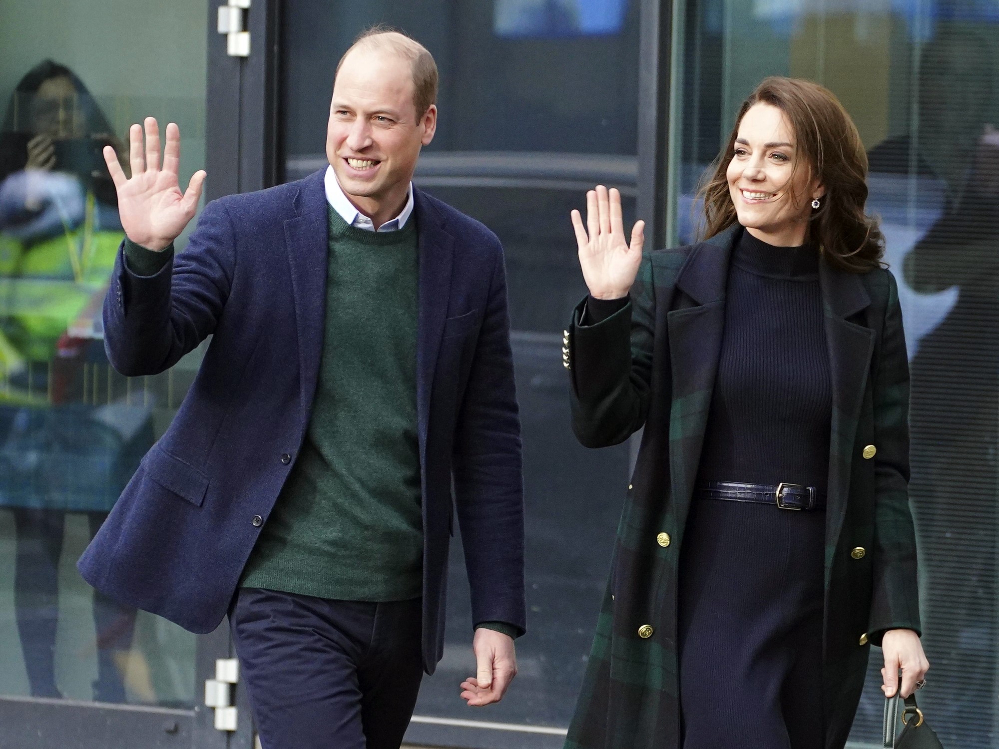 Britain's Prince William and Kate, Princess of Wales wave as they walk. 