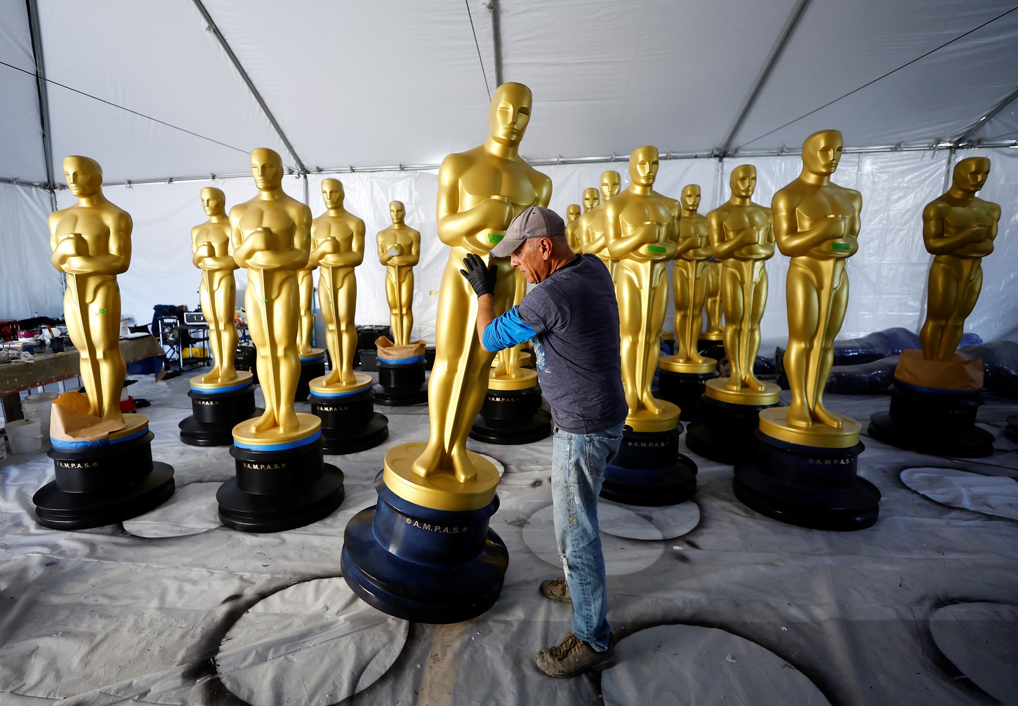 Un ouvrier a déplacé des statues géantes d'Oscar lors des préparatifs du grand soir.
