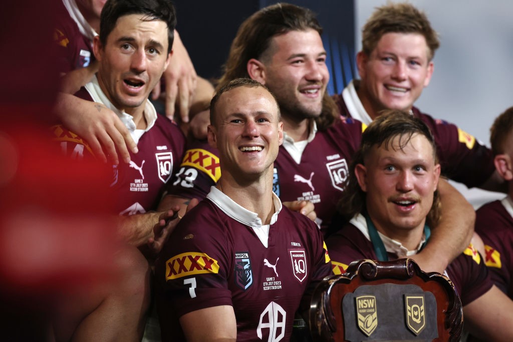 Queensland Maroons sit with the State of Origin shield.