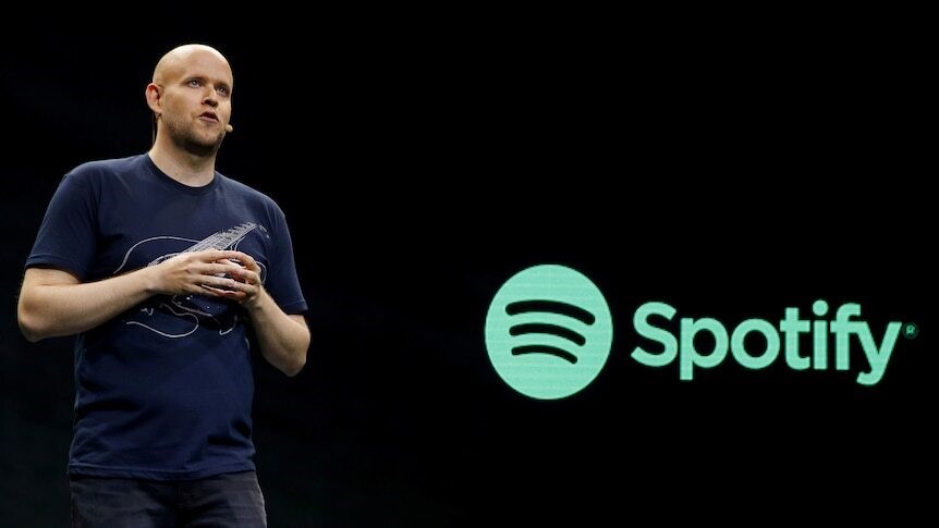 Daniel speaks on stage in front of the Spotify logo.