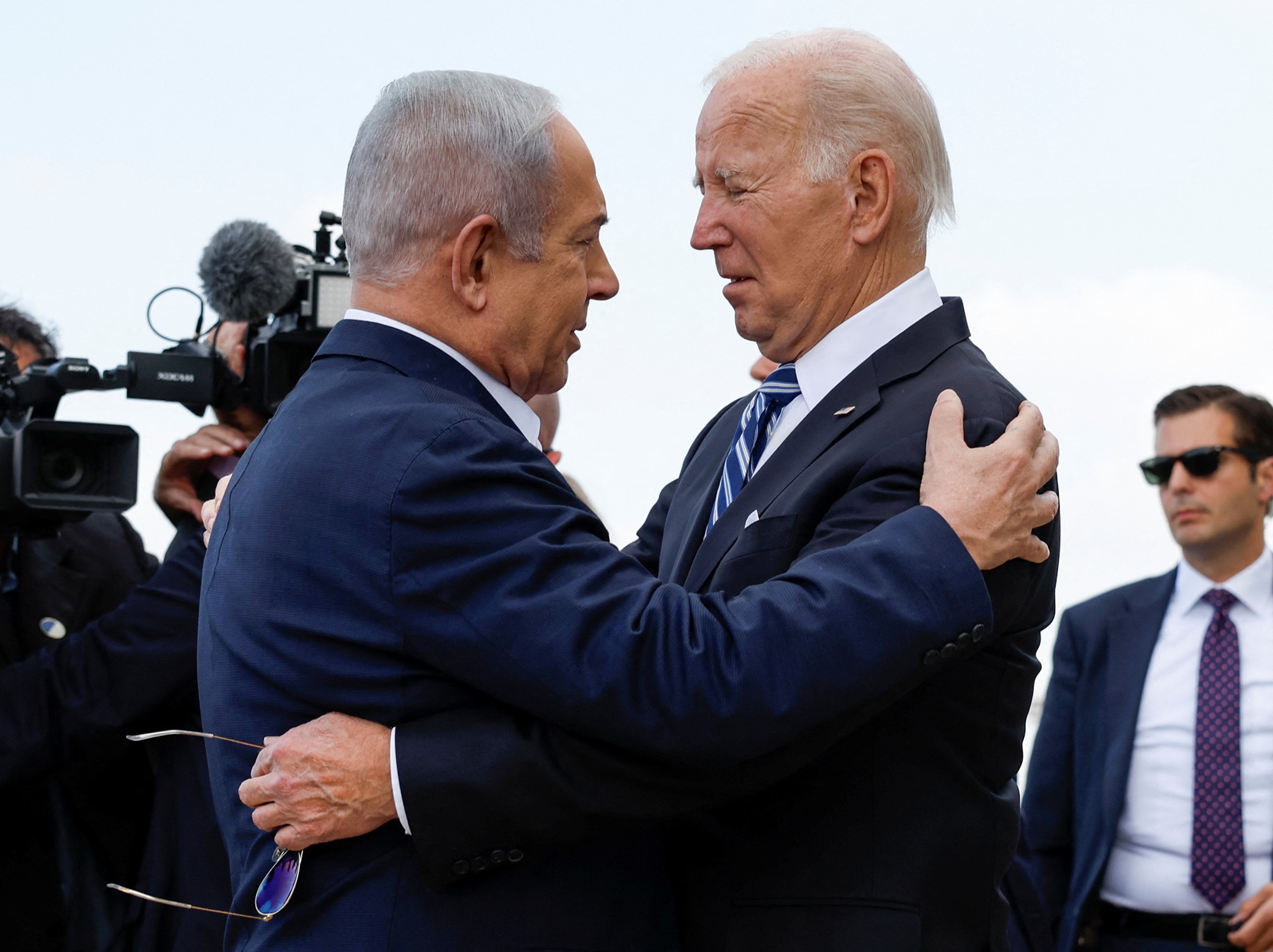 Two old men embracing with hands on each other.