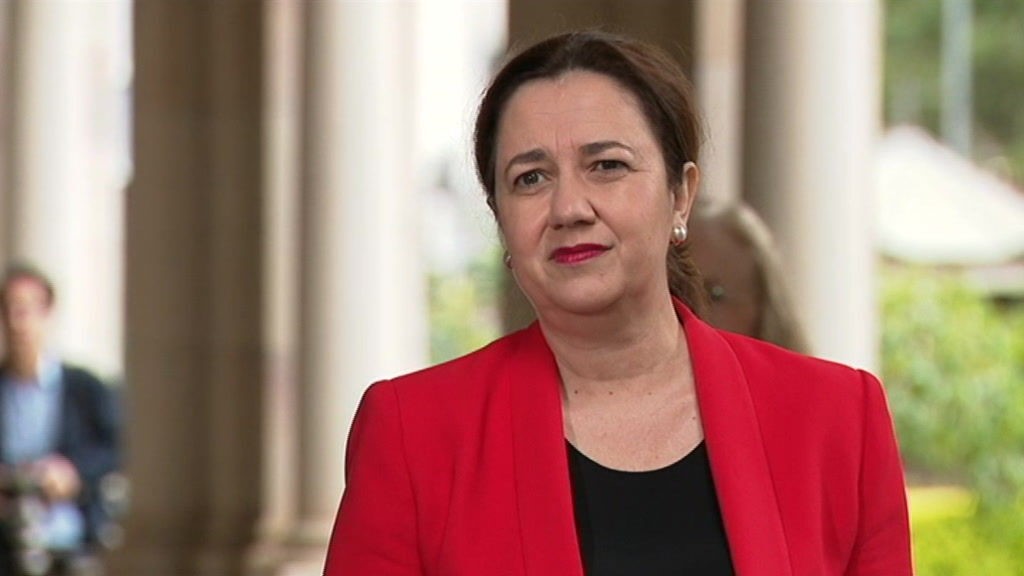 Annastacia Palaszczuk wearing a red blazer standing outside.