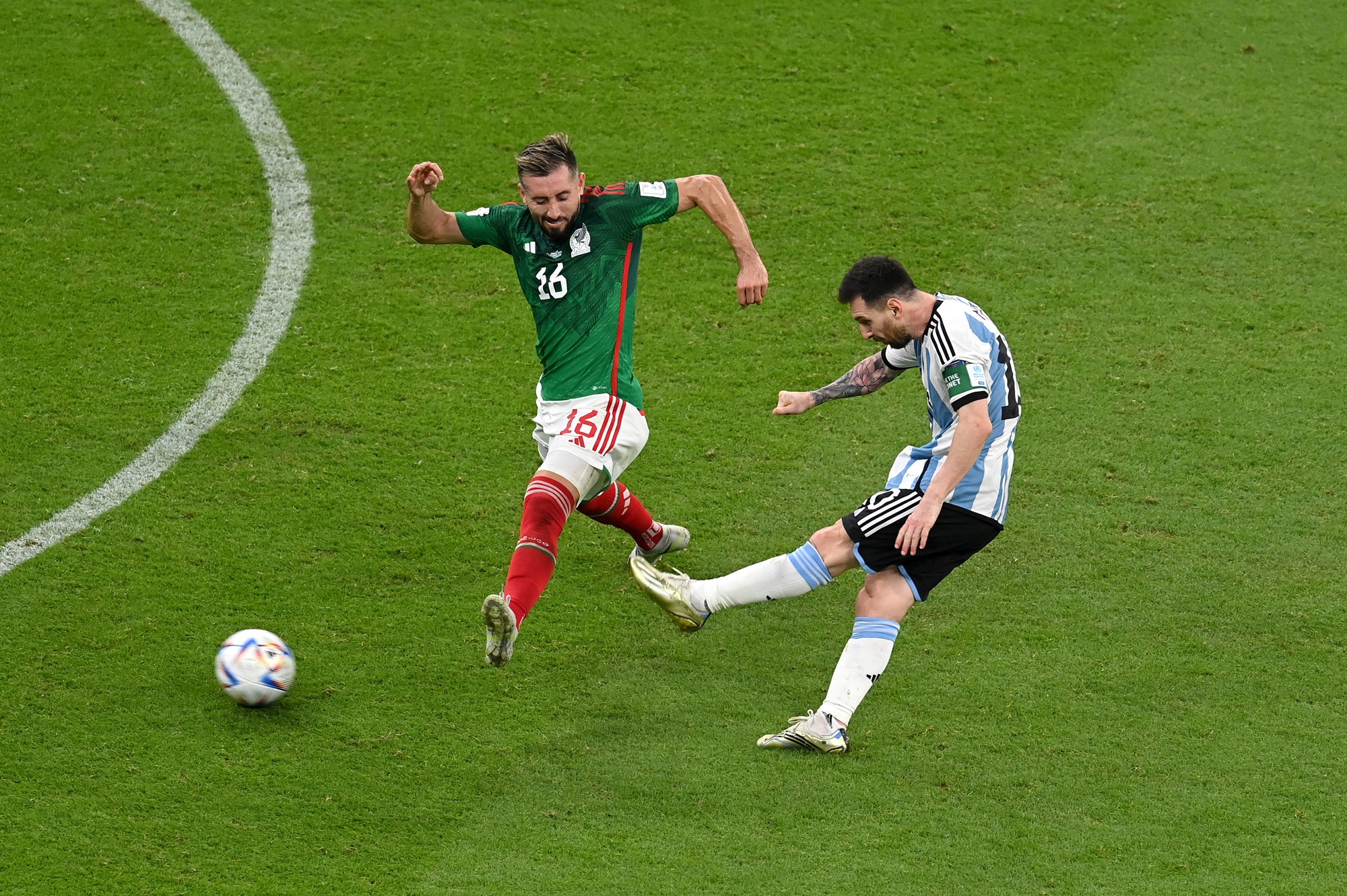 Argentina's Lionel Messi strikes the ball with his left foot for a goal as a Mexican defender makes a lunge.